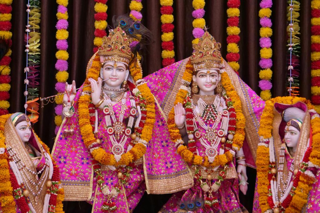 Vibrant statues adorned with flowers and garlands in Govardhan, India.